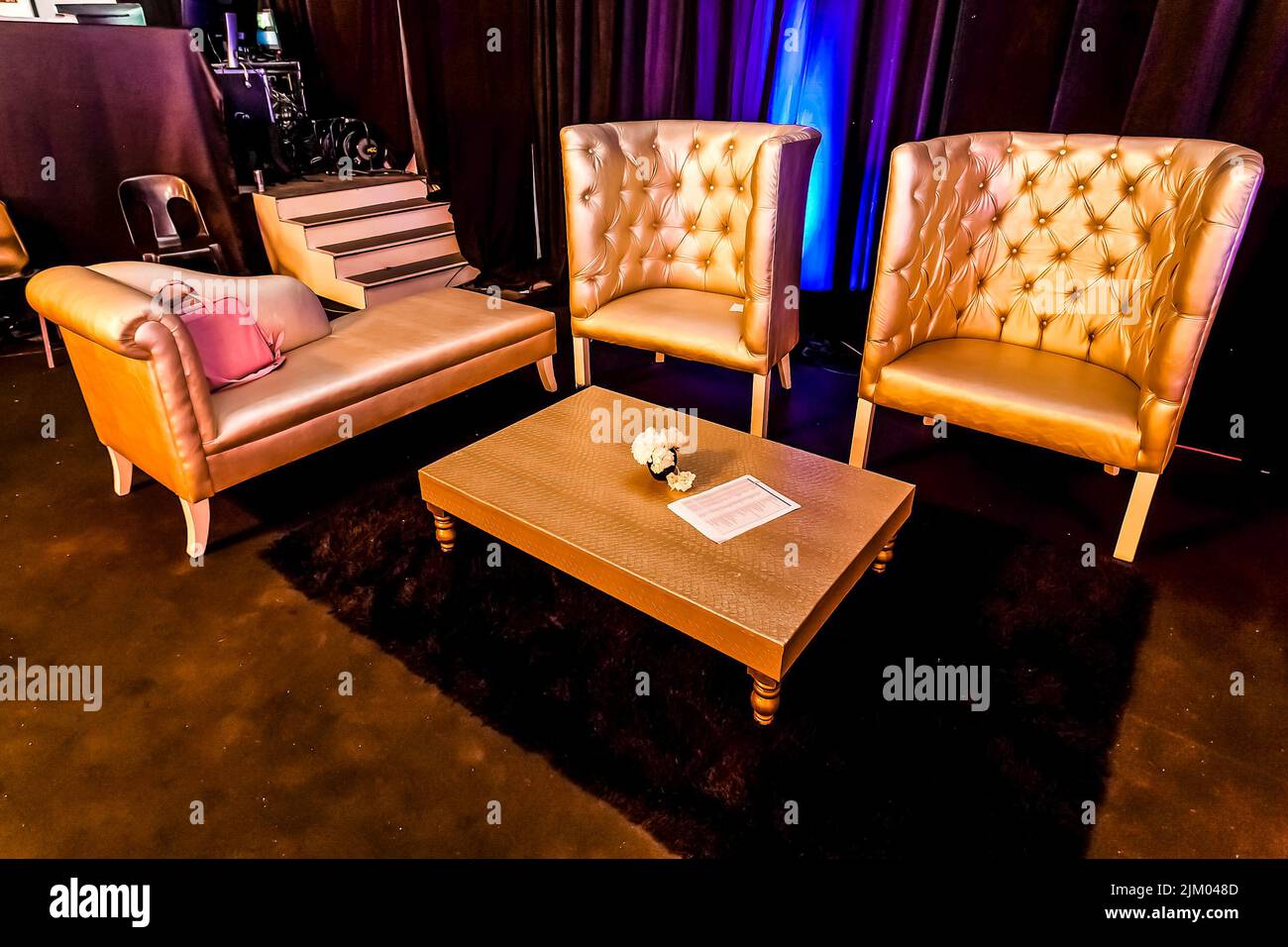 Gli interni sono decorati in modo lussuoso con poltrone e un tavolo su un tappeto durante un evento di festa Foto Stock