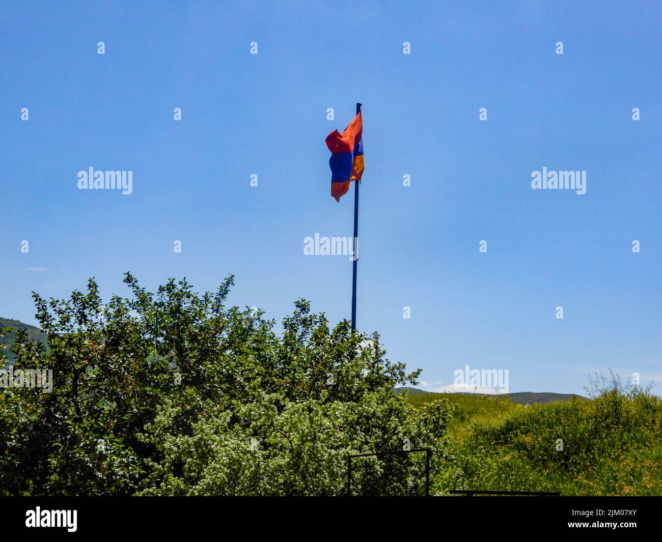Un primo piano di ondeggiamento della bandiera nazionale della Repubblica di Armenia nel campo di montagna Foto Stock