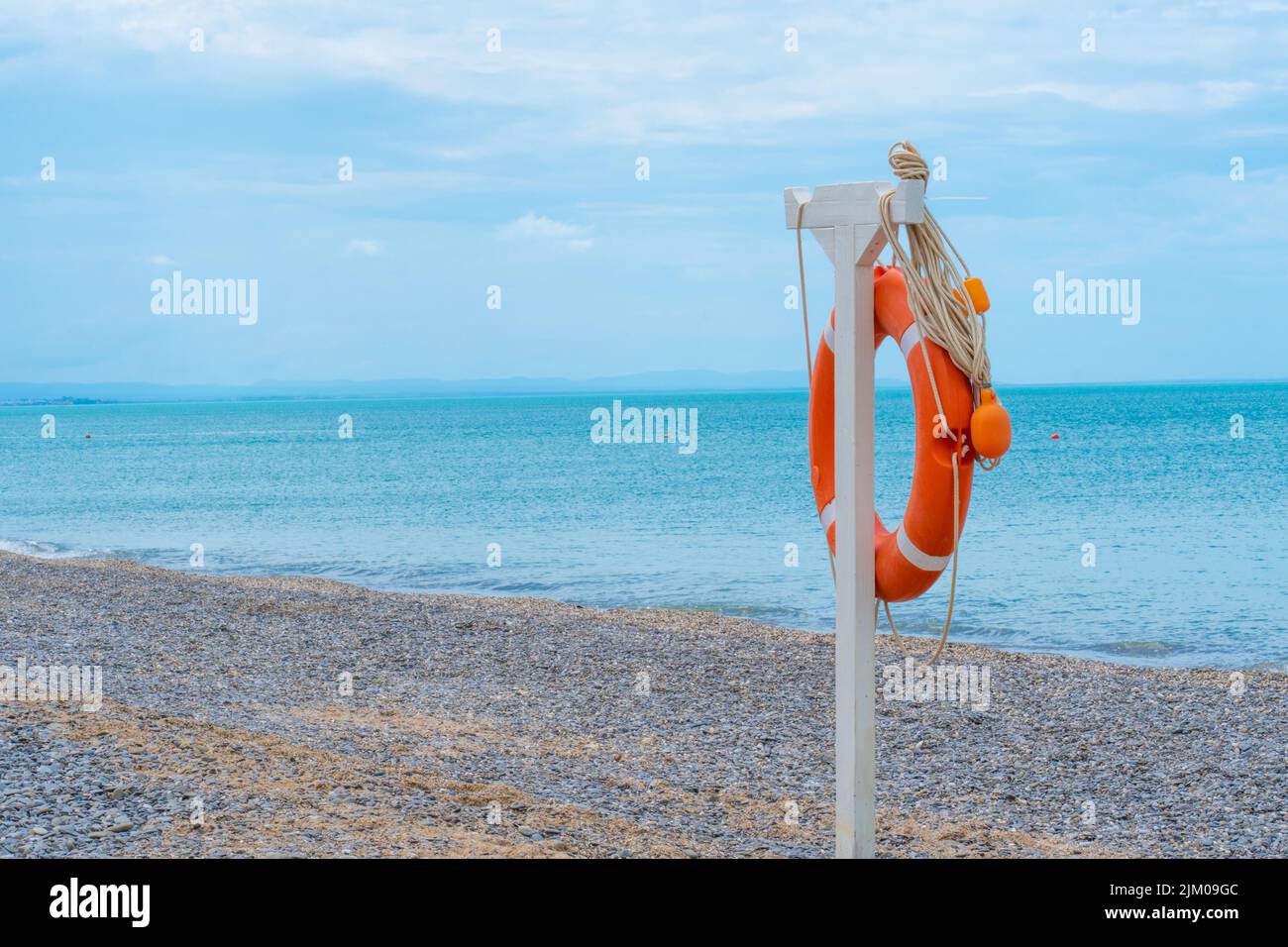 Life ring spiaggia mare buoy arancione closeup salvataggio di salvataggio rotondo, concetto rosso guardia da emergenza da assistenza oceano, cassaforte a terra. Contesto di sopravvivenza Foto Stock