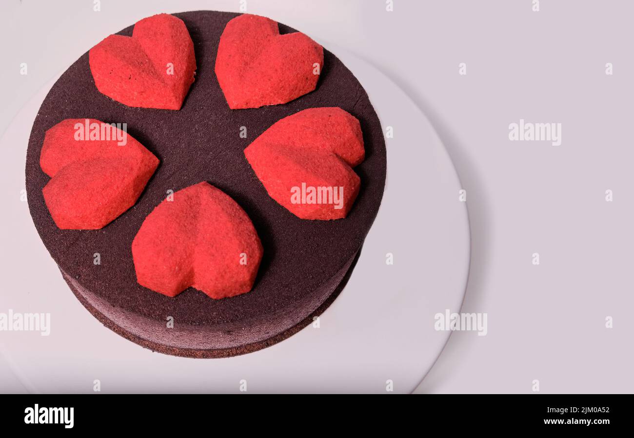Torta marrone al cioccolato decorata con cuore di topo rosso sulla parte superiore Foto Stock
