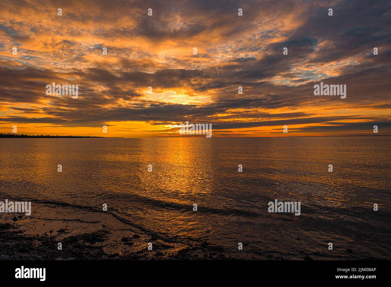 Una bellissima spiaggia di mare al tramonto arancione Foto Stock