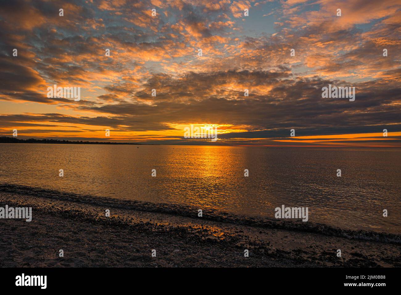 Una bellissima spiaggia di mare al tramonto arancione Foto Stock