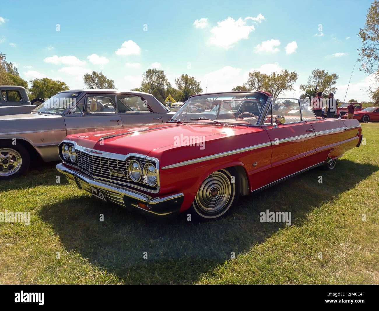 Chascomus, Argentina - Apr 09, 2022: Vecchio popolare rosso Chevrolet Chevy Impala SS Super Sport V8 due porte convertibile 1964 da GM in campagna. Natu Foto Stock