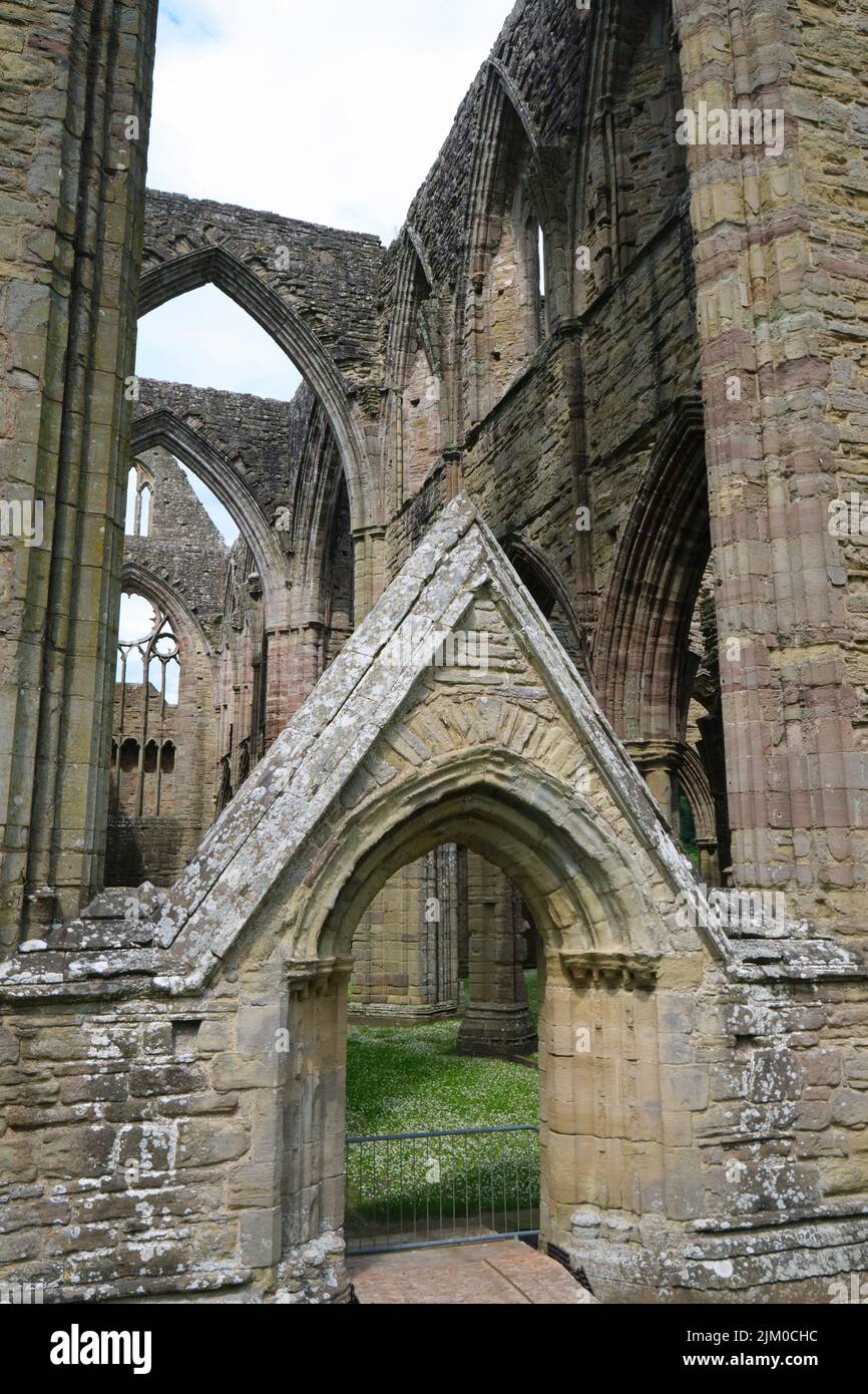 Una delle porte ad arco, appuntite, in pietra, porte alla cattedrale. A Tintern Abby vicino a Chepstow, Galles, Regno Unito. Foto Stock