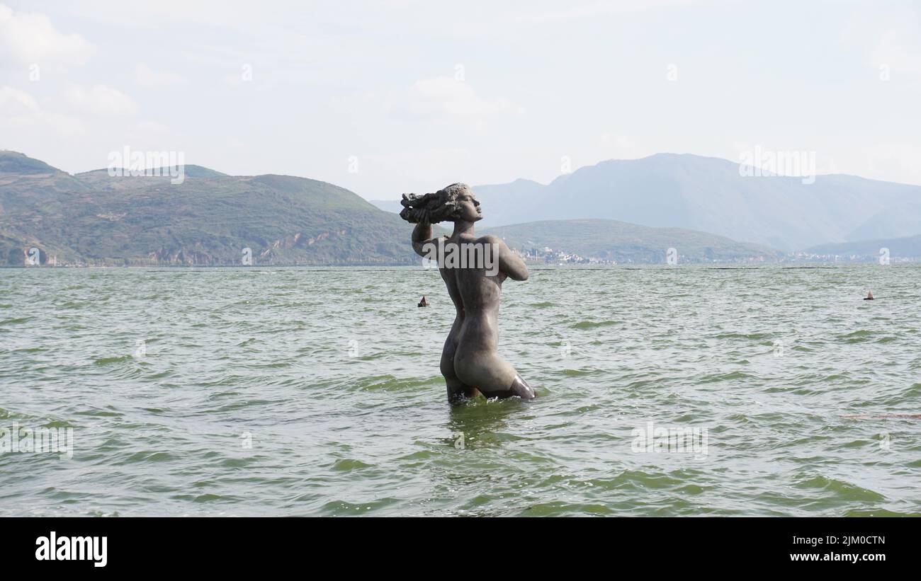 Una statua di una donna in mare Foto Stock