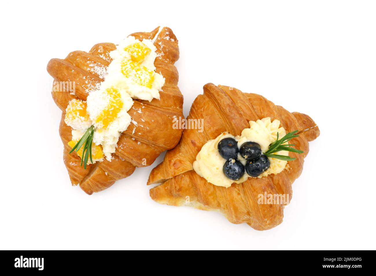 Una vista dall'alto di deliziosi croissant con guarnizione di frutta isolata su sfondo bianco Foto Stock