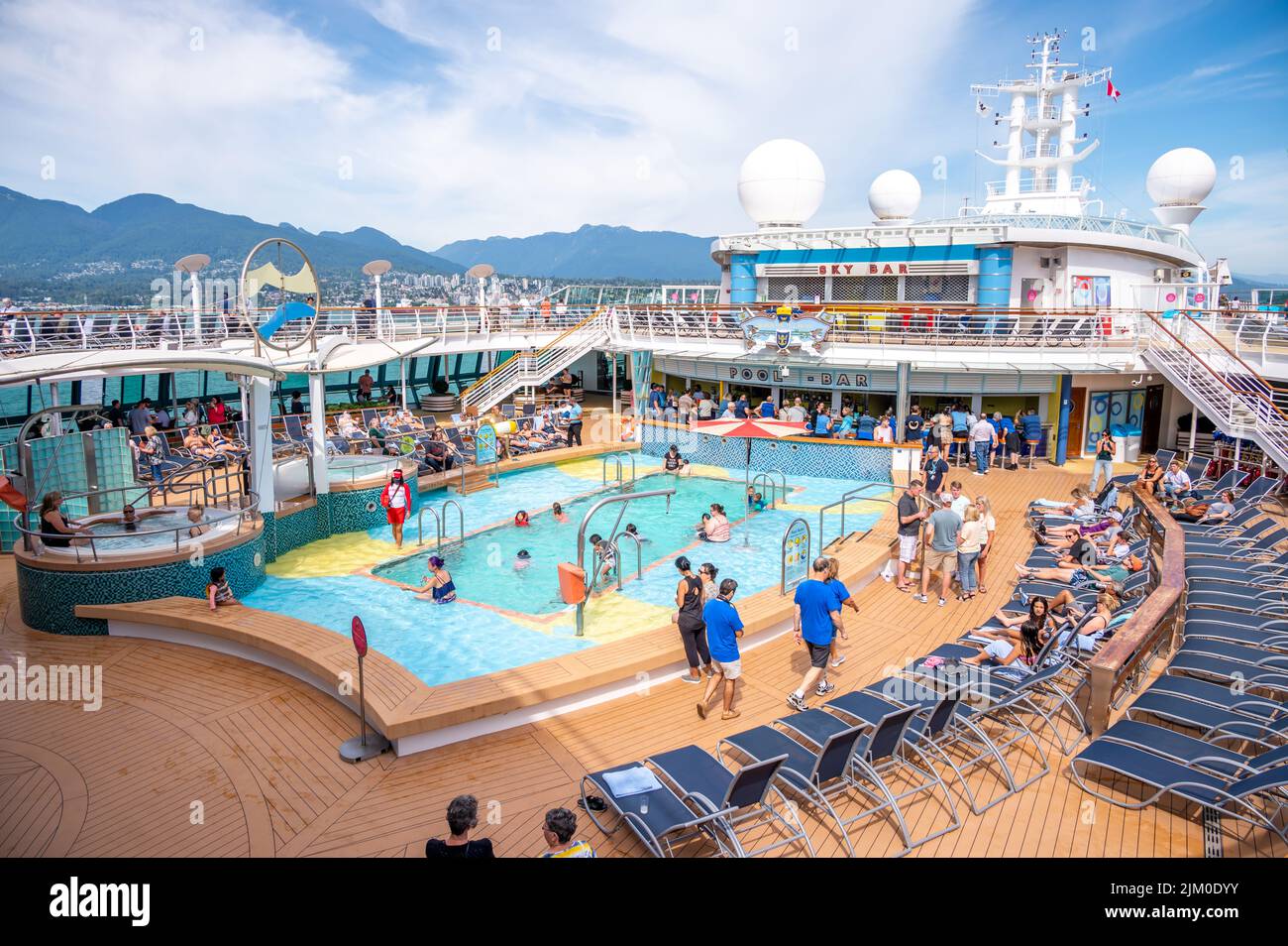 Vancouver, British Columbia - 24 luglio 2022: L'area piscina della Serenata dei mari dei Caraibi reali con le montagne costo sullo sfondo. Foto Stock
