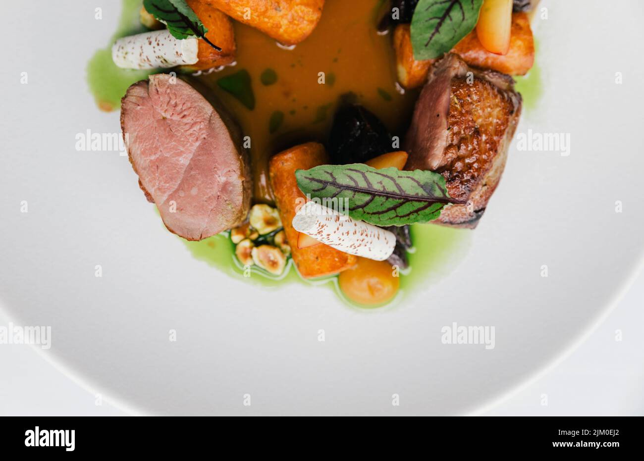 Un top shot di un piatto gourmet con carne, verdure e salsa Foto Stock