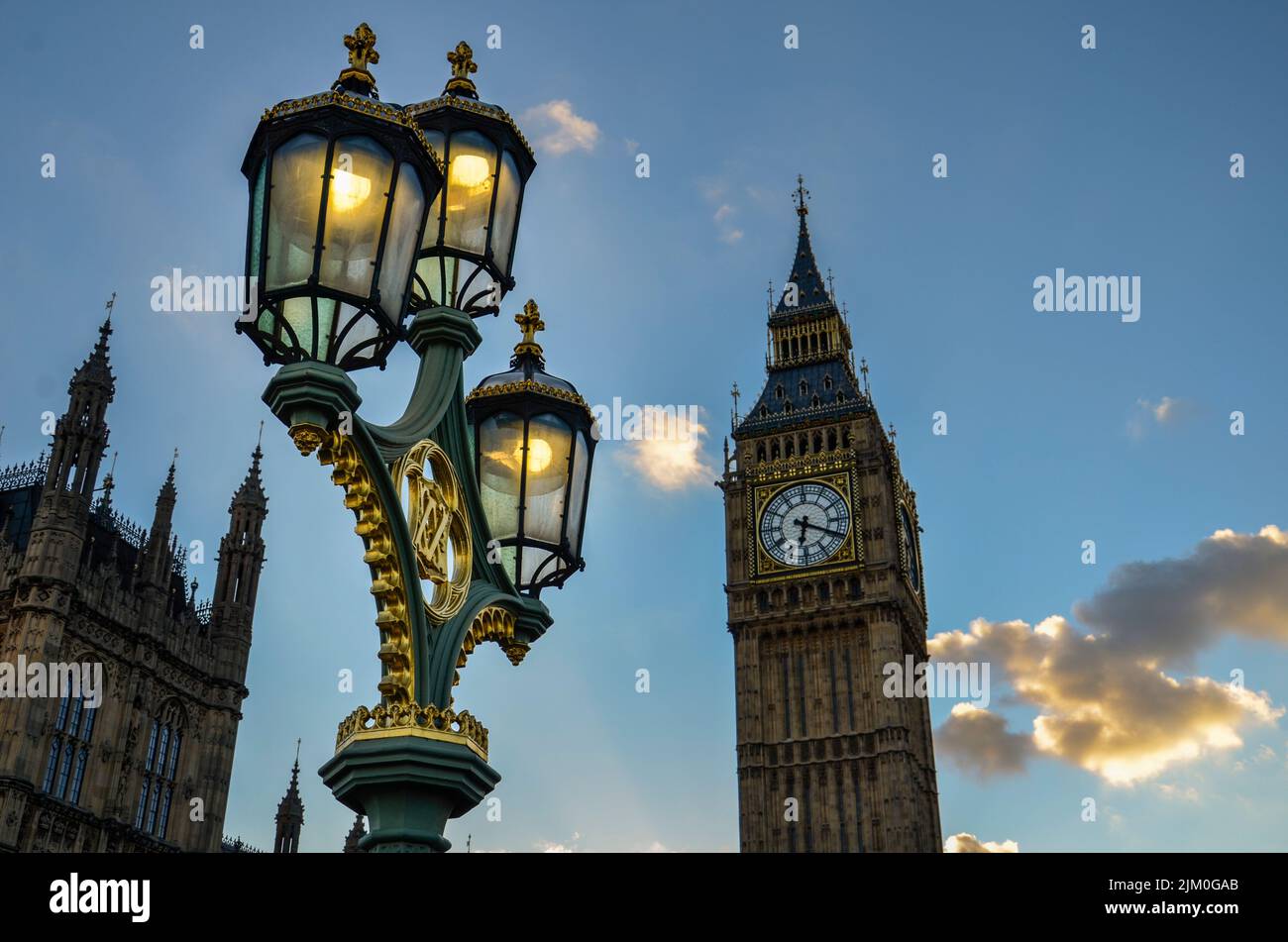 Belle luci di strada su uno sfondo del famoso Big ben sotto un cielo blu e nuvoloso, Londra Foto Stock