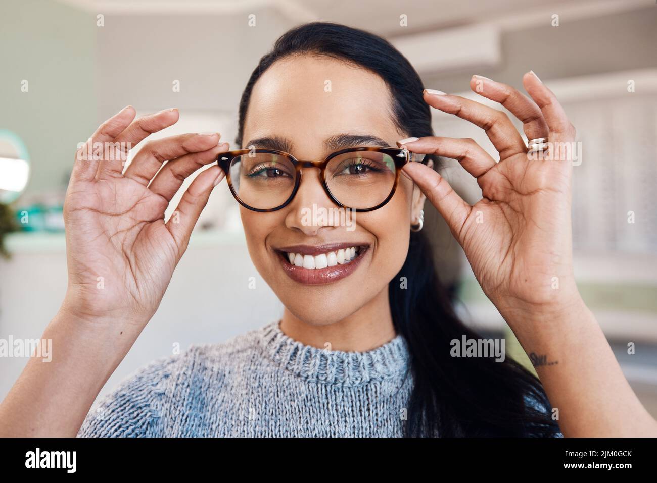 Il futuro mi sembra bello. Una giovane donna che acquista un nuovo paio di occhiali in un negozio di optometristi. Foto Stock