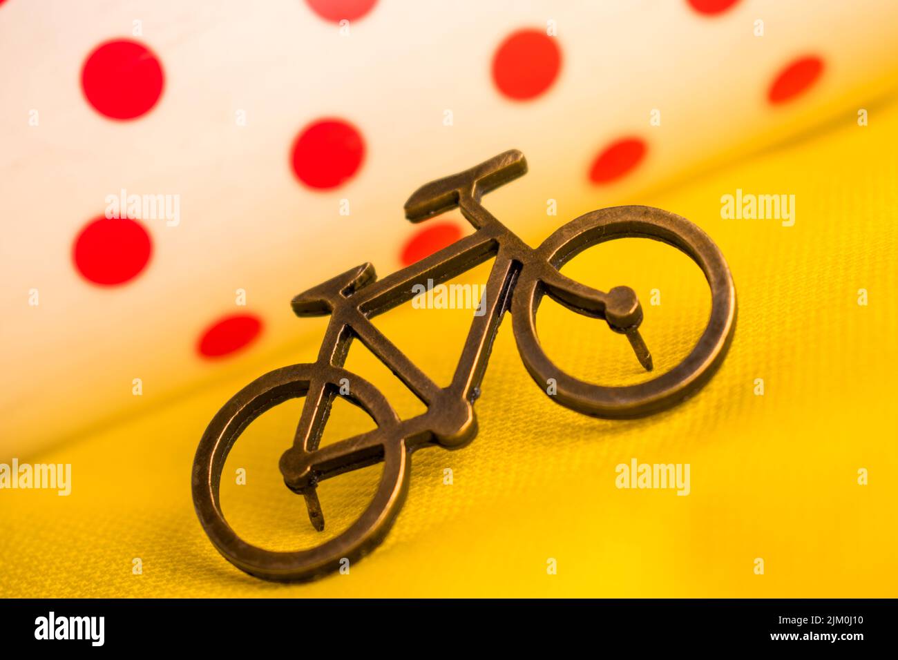 Un piccolo spilla per bicicletta su una t-shirt gialla per un tour della Francia con sfondo sfocato Foto Stock