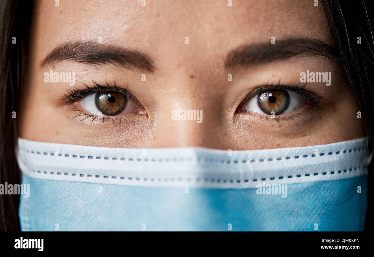 Covid-19 sta influendo sui modi di vita in tutto il mondo. Ritratto di una donna che indossa una maschera facciale. Foto Stock