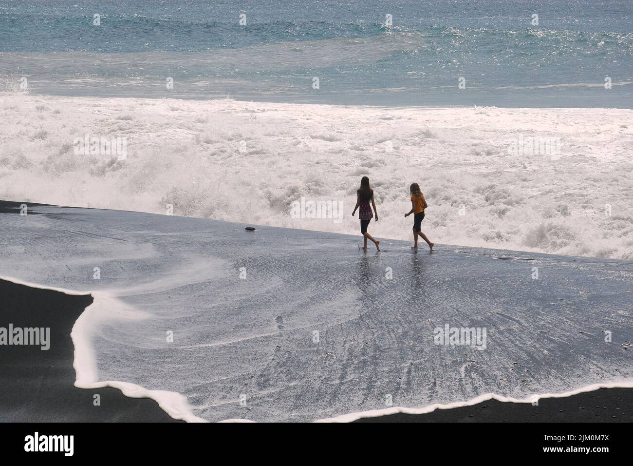 I turisti che si godono una passeggiata sulla spiaggia Foto Stock