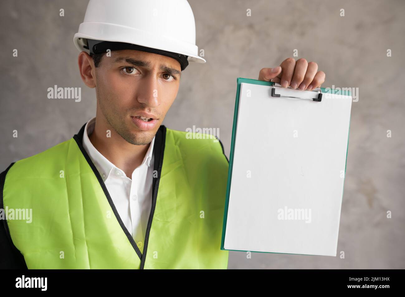 Architetto in un elmetto bianco e giubbotto di sicurezza con una clipboard per la vostra pubblicità Foto Stock