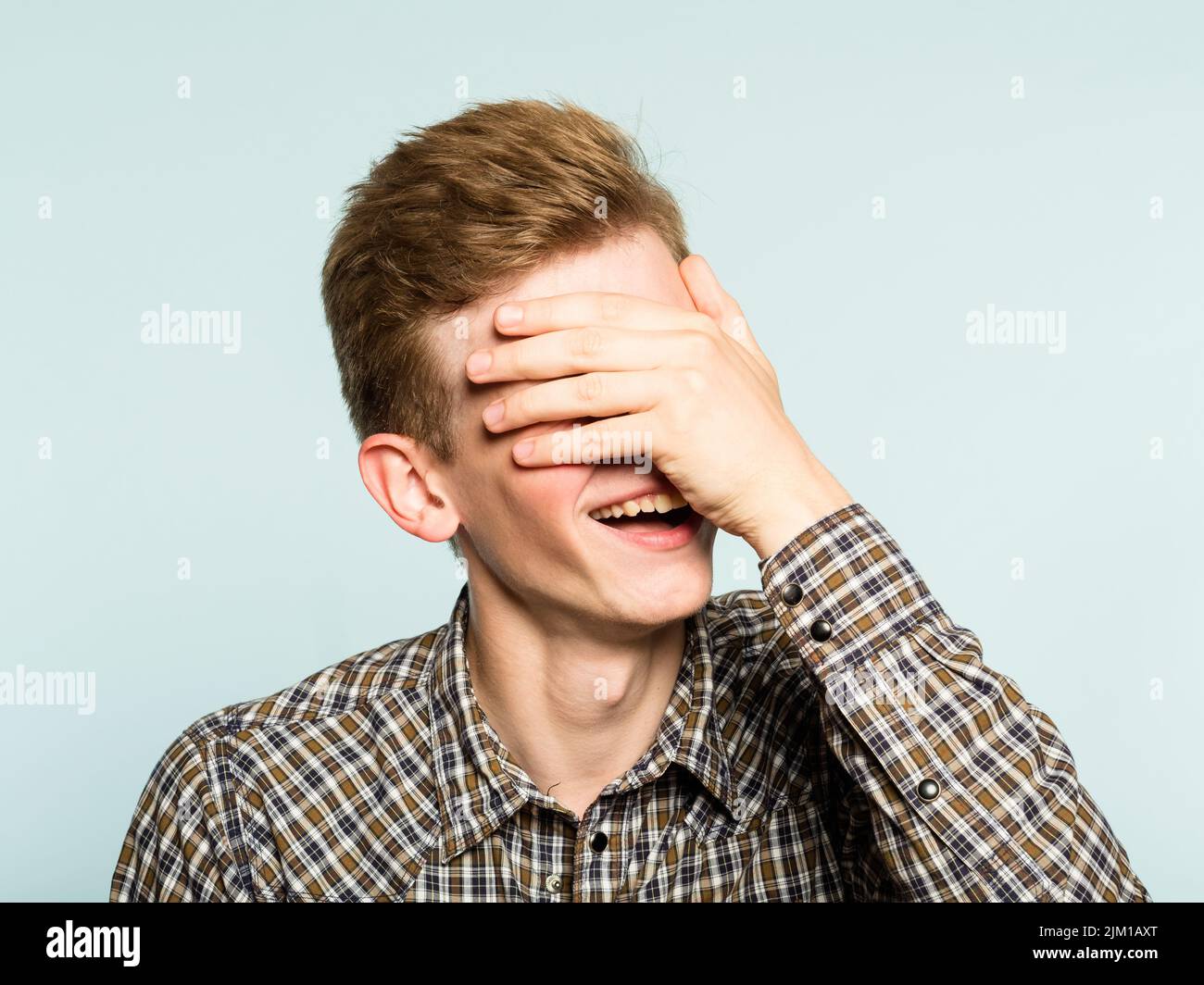 facepalm felice sorridente uomo gioioso coprire faccia vergogna Foto Stock