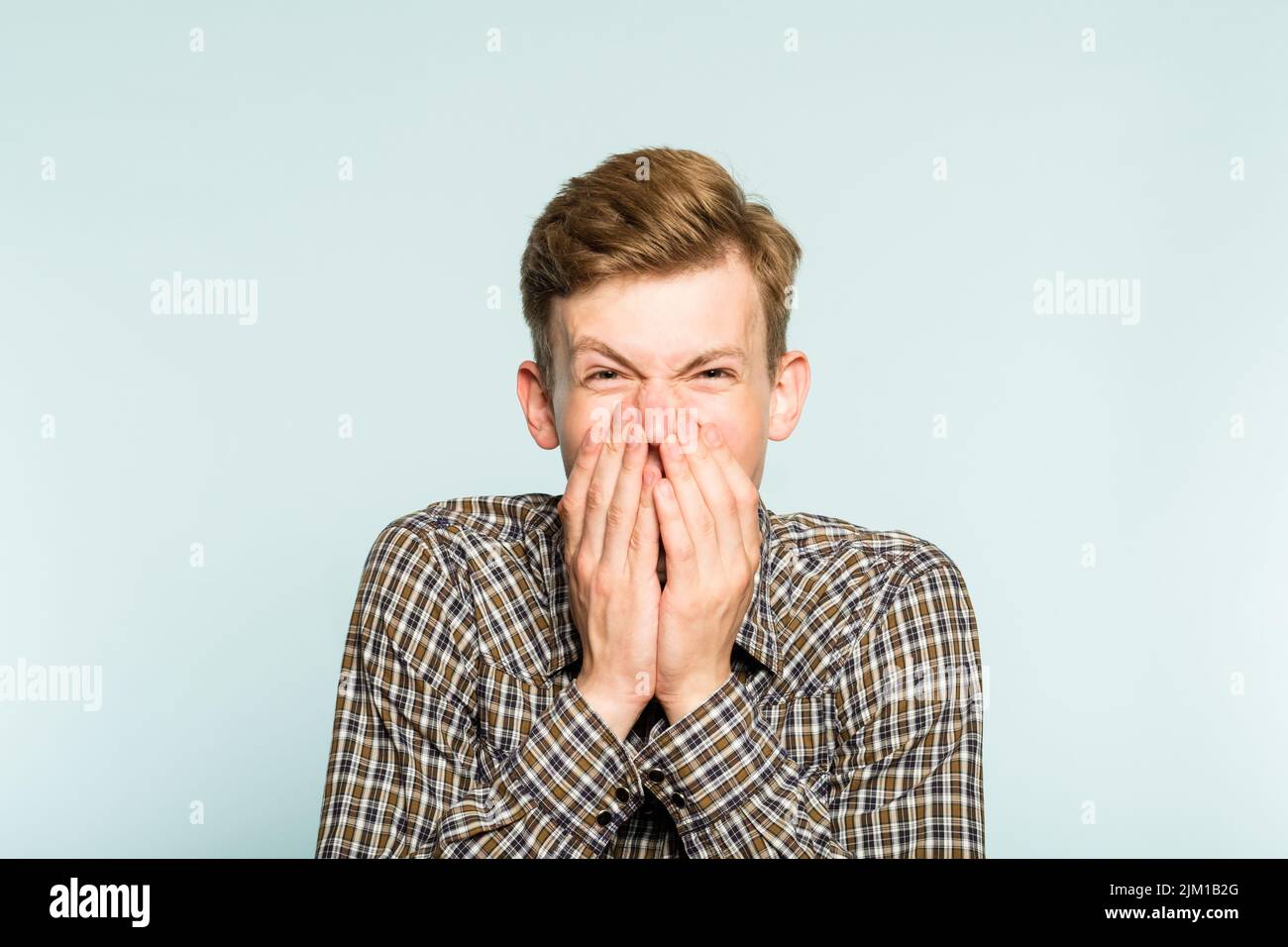 felice felice eccitato gioioso uomo che copre l'emozione della bocca Foto Stock