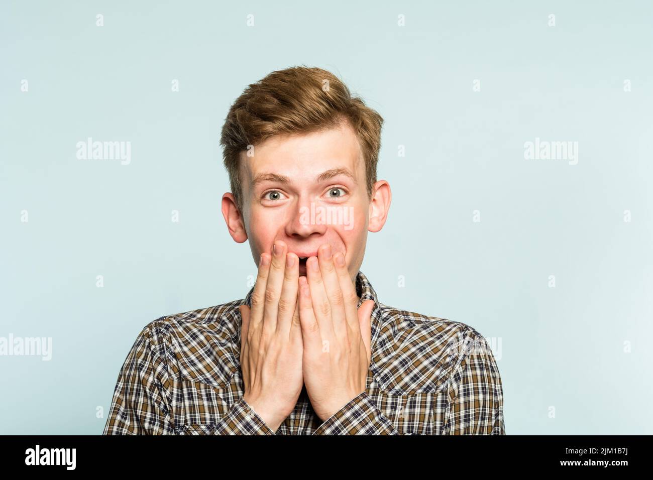 felice felice eccitato gioioso uomo che copre l'emozione della bocca Foto Stock