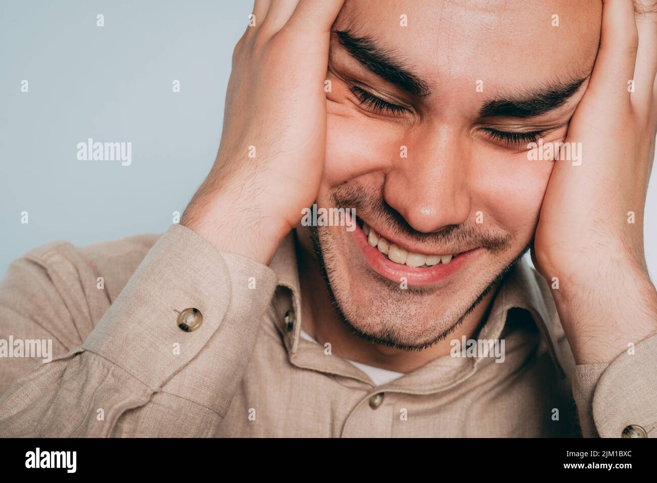 felice uomo gioioso ridendo la testa di tenuta mani Foto Stock