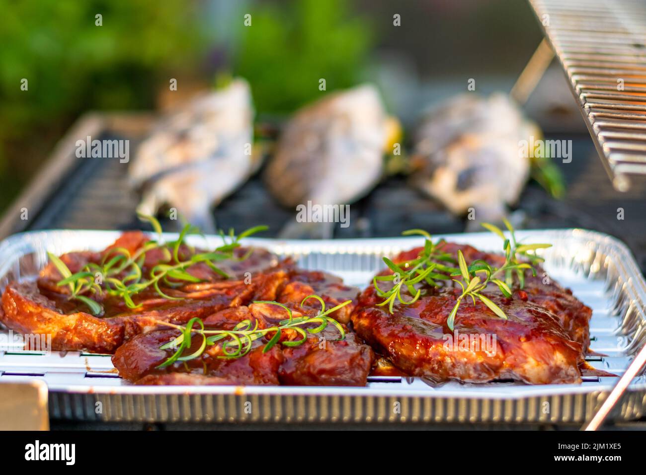 Orata di mare dorado pesce posto sulla griglia. Pesce fresco con erbe e limone. Barbecue estivo Foto Stock