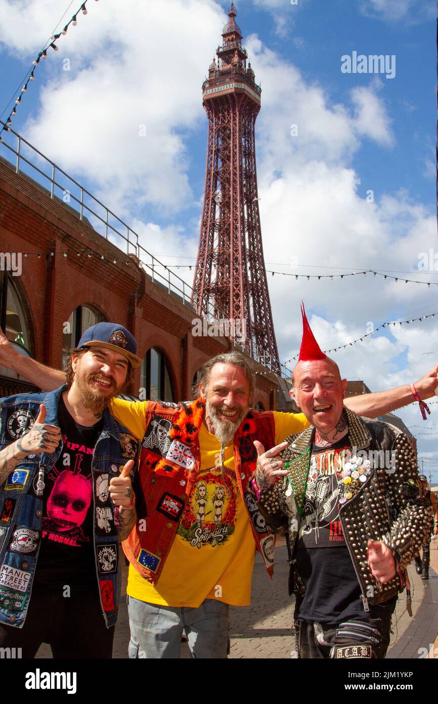 Blackpool, Lancashire, Regno Unito. 4th ago 2022. Barry, ROV e Jonnie difendono la sottocultura punk, le ideologie e la moda, con acconciature e colorazioni tinte Mohican al festival della ribellione punk presso i Winter Gardens. Una protesta contro atteggiamenti e comportamenti convenzionali, uno scontro di culture anti-establishment, mohawks, spille di sicurezza e un carico di atteggiamento alla città di mare come pugni che partecipano al festival annuale di musica rock Rebellion presso i Giardini invernali vengono a fianco a fianco con i tradizionali turisti. Credit: MediaWorldimages/AlamyLiveNews Foto Stock