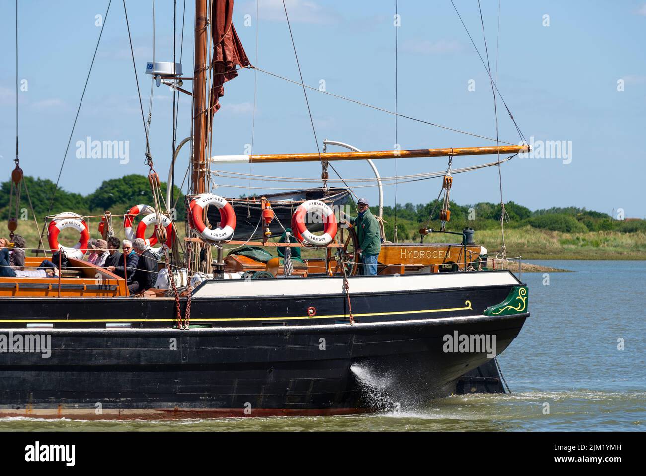 Hydrogen, una storica barca a vela del Tamigi, che naviga verso Maldon Hythe Quay sul fiume Blackwater, Maldon, Essex, Regno Unito. Stern, con timoniere Foto Stock