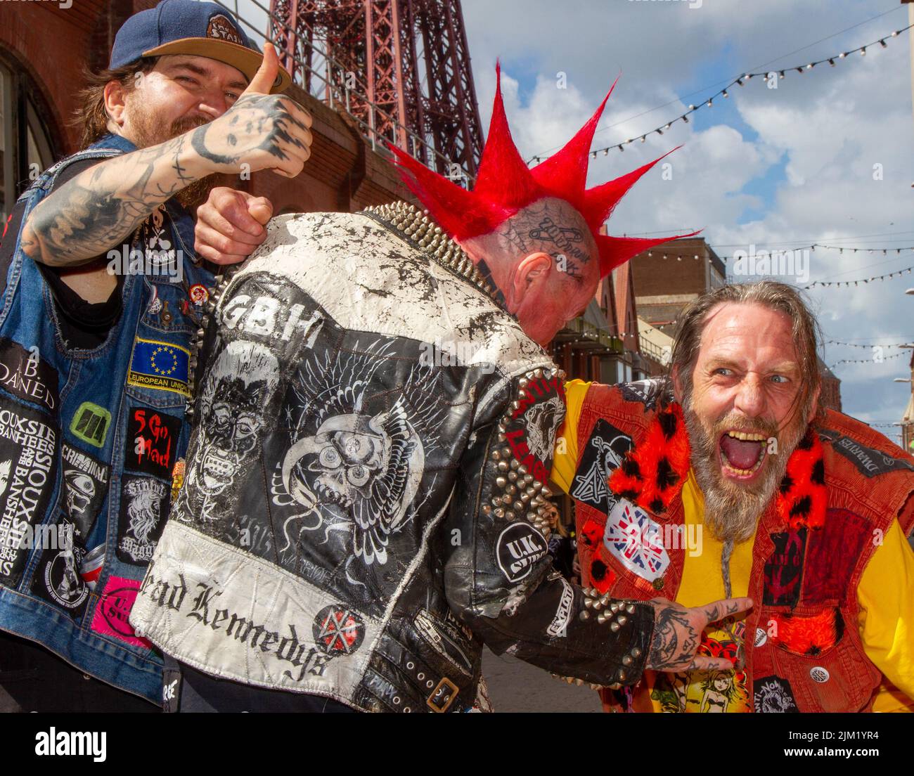 Punk Rockers indossa una giacca a punta in cuoio pesante Blackpool, Lancashire, UK. 4th ago 2022. Barry, ROV e Jonnie sostengono la sottocultura punk, ideologie, moda, e Mohican tinteggiato acconciature e colorazione al festival punk Rebellion presso i giardini invernali. Una protesta contro atteggiamenti e comportamenti convenzionali, uno scontro di culture anti-establishment, mohawks, spille di sicurezza e un carico di atteggiamento presso la città sul mare, mentre i punk che partecipano all'annuale festival di musica rock Rebellion presso i Winter Gardens si scontrano con i turisti tradizionali. Foto Stock