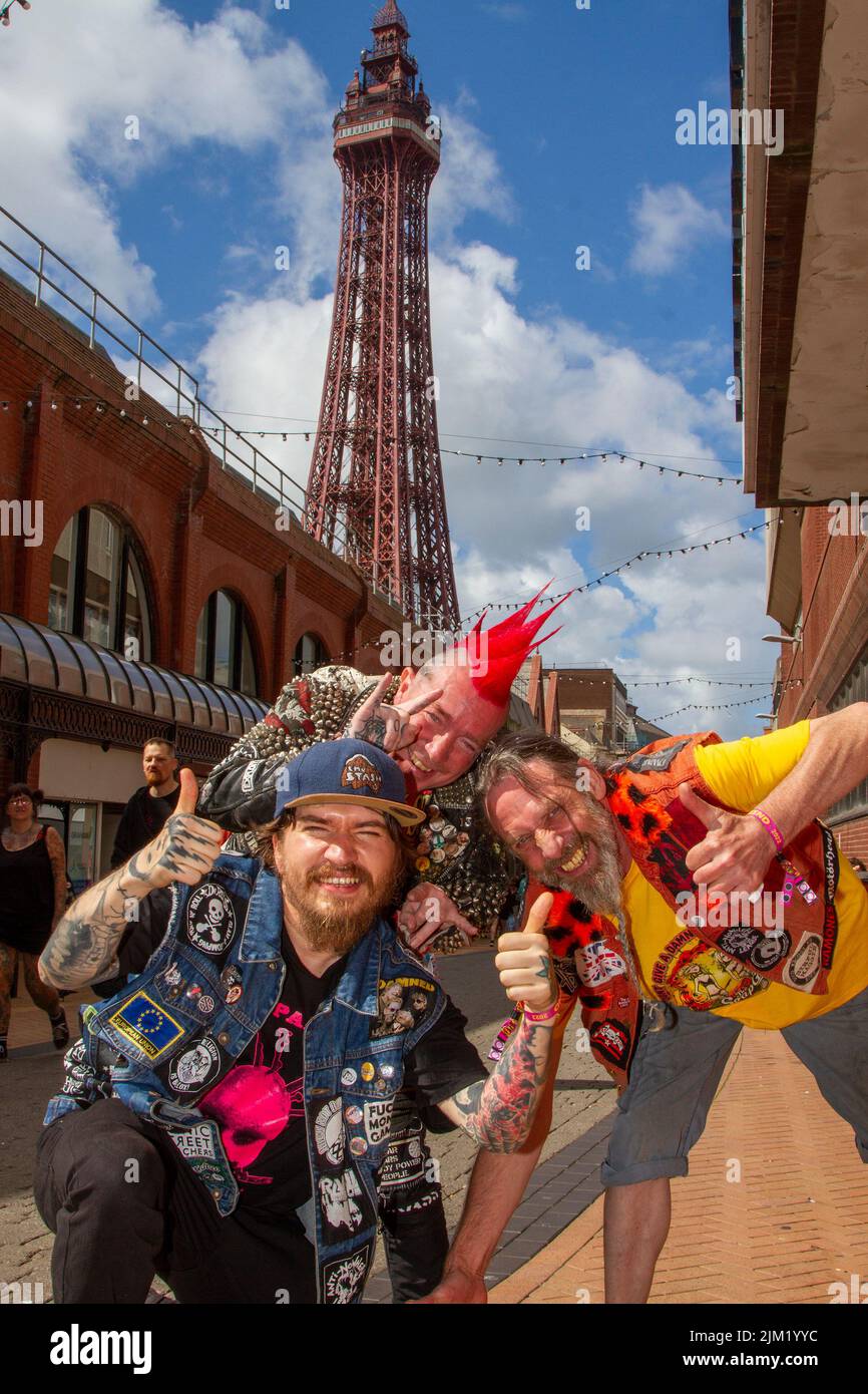 Blackpool, Lancashire, Regno Unito. 4th ago 2022. Barry, ROV e Jonnie difendono la sottocultura punk, le ideologie, la moda, con acconciature e colorazioni Mohican al festival punk Rebellion presso i Winter Gardens. Una protesta contro atteggiamenti e comportamenti convenzionali, uno scontro di culture anti-establishment, mohawks, spille di sicurezza e un carico di atteggiamento alla città di mare come pugni che partecipano al festival annuale di musica rock Rebellion presso i Giardini invernali vengono a fianco a fianco con i tradizionali turisti. Credit: MediaWorldimages/AlamyLiveNews Foto Stock