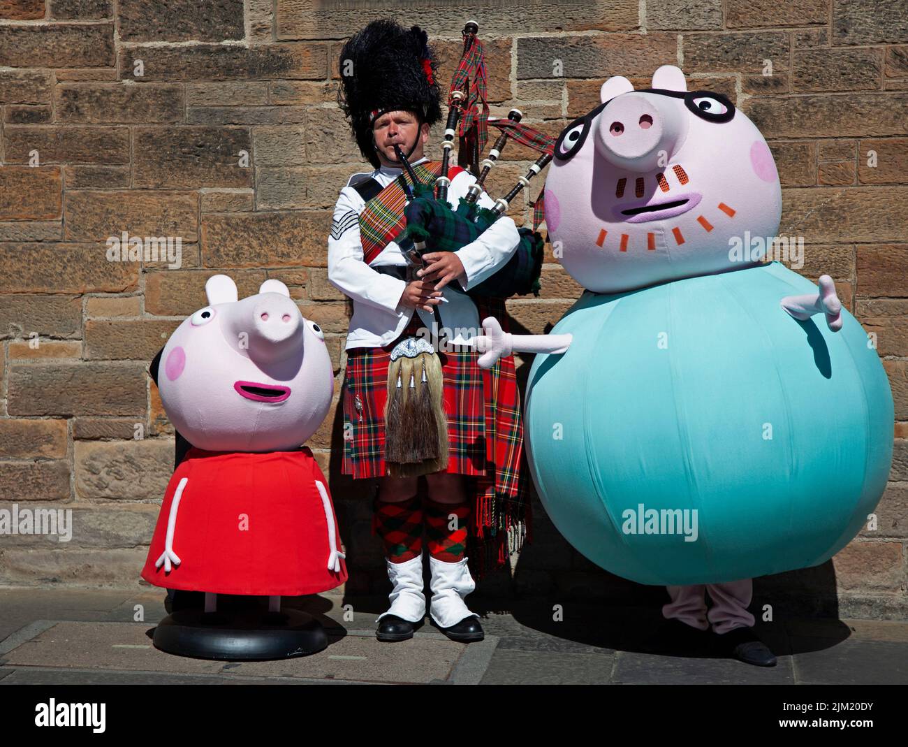 Edimburgo, Scozia, Regno Unito. 4th agosto 2022. EdFringe Photocall: Peppa, e Daddy Pig sull'iconico Royal Mile con il piper DAVIE Barton per festeggiare il loro spettacolo di famiglia Peppa Pig: Il mio primo concerto al Fringe, presentando i piccoli piggies alla musica classica con l'ispiratrice Aurora Orchestra. Credit: ArchWhite/alamy Live news. Foto Stock