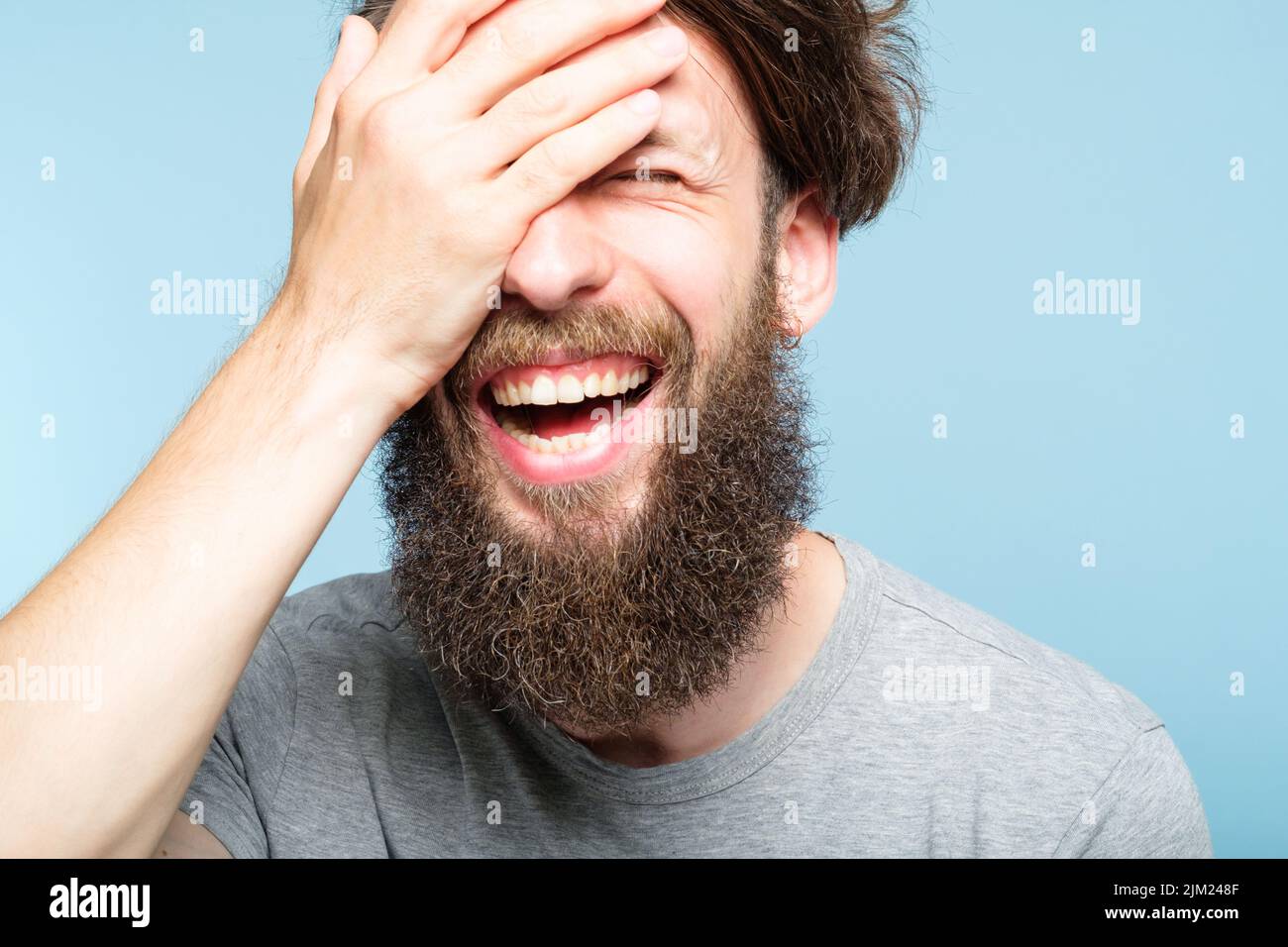 facepalm felice sorridente uomo gioioso coprire faccia vergogna Foto Stock