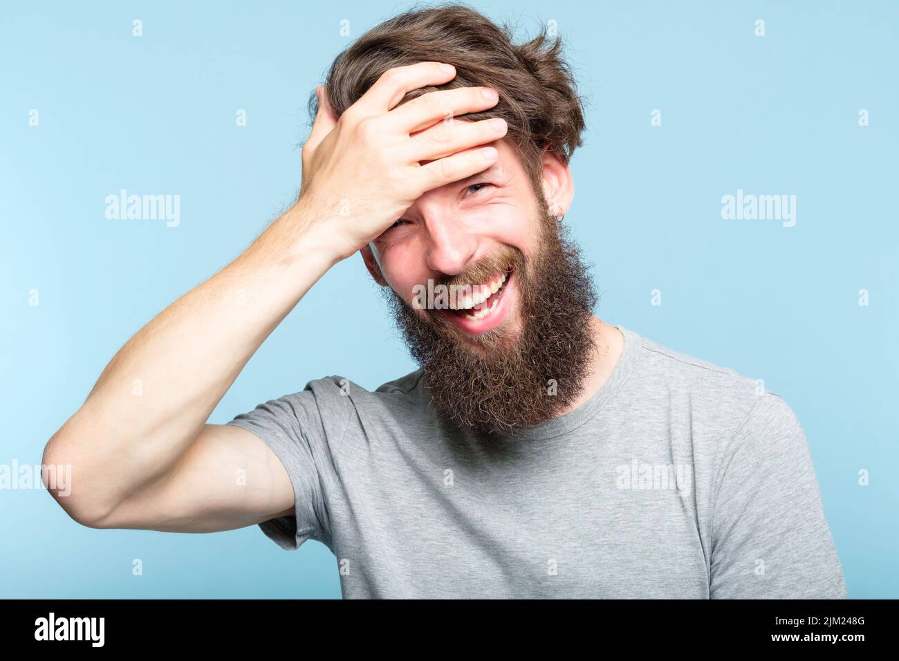 facepalm uomo sorridente copertina faccia vergogna imbarazzo Foto Stock