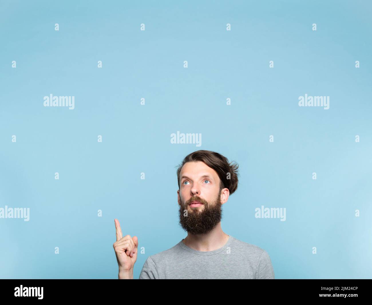 l'uomo punta in su sopra la pubblicità bearded dell'ippster Foto Stock