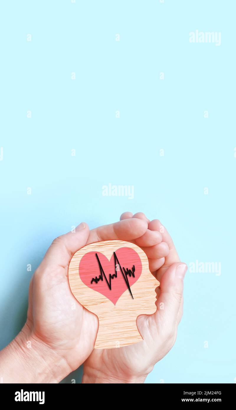 Mani che tengono cervello e cuore in legno, ictus cerebrale, giorno del cuore del mondo, giorno della salute mentale del mondo, concetto di Alzheimer. Foto Stock