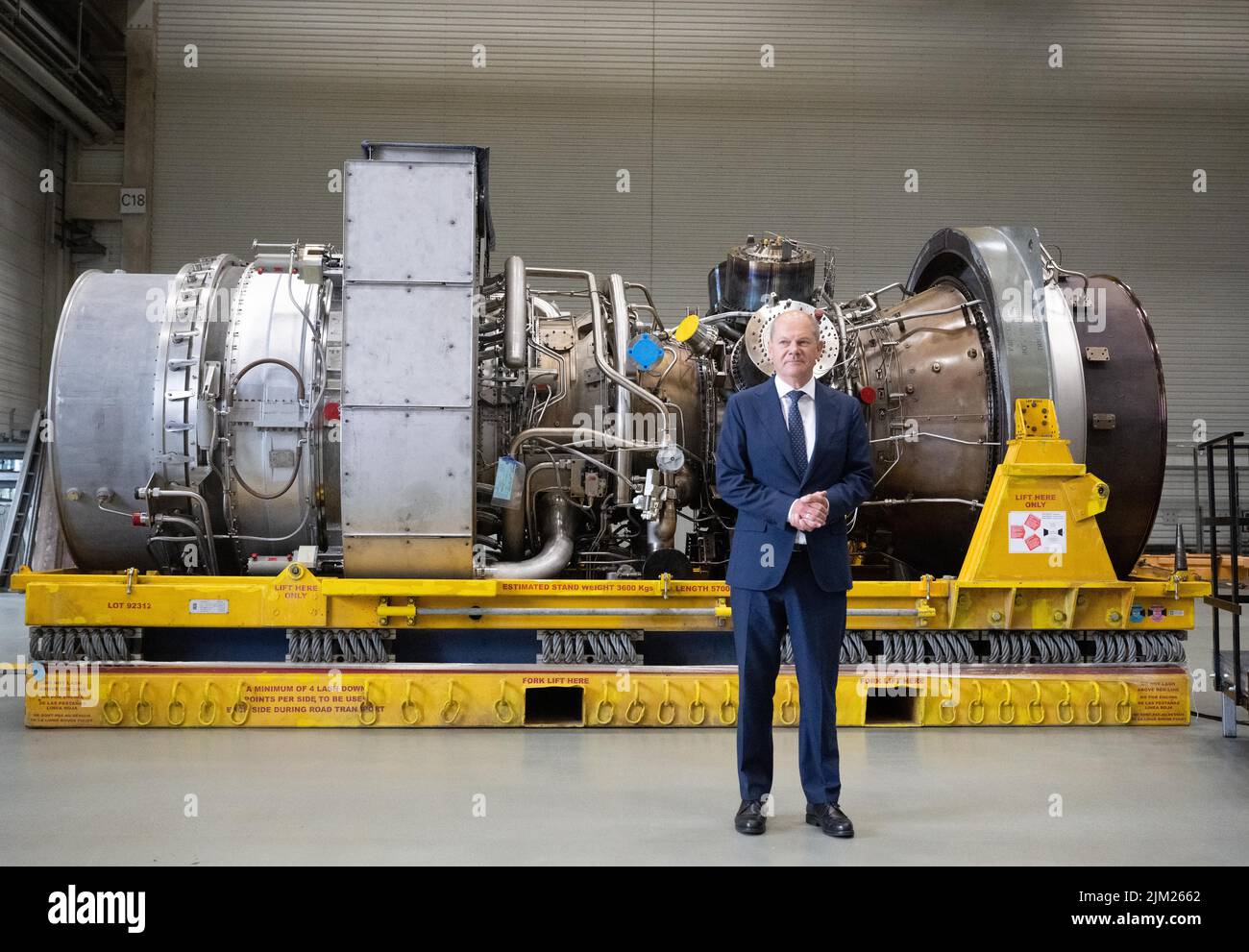 03 agosto 2022, Renania settentrionale-Vestfalia, Mülheim an der Ruhr: Il cancelliere tedesco OLAF Scholz (SPD) si trova di fronte alla turbina servita in Canada per il gasdotto Nordstream 1. E' pronta per il trasporto in Russia. Foto: Bernd Thissen/dpa Foto Stock