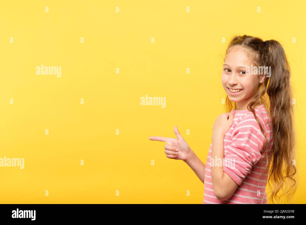 guardi sinistra sorridente ragazza punta il dito che fa pubblicità Foto Stock