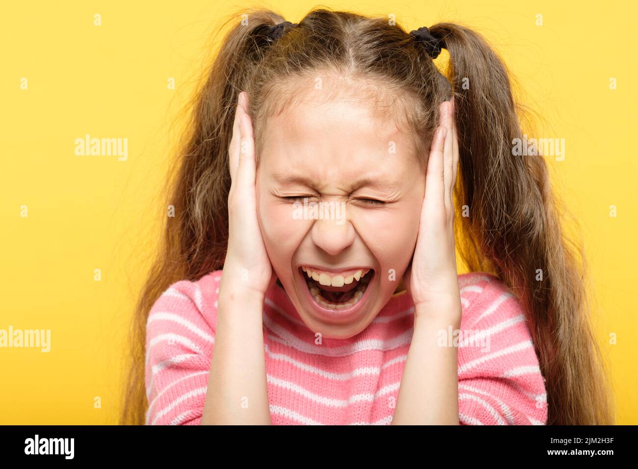 spaventato urlante ragazza coprire le orecchie stressate Foto Stock