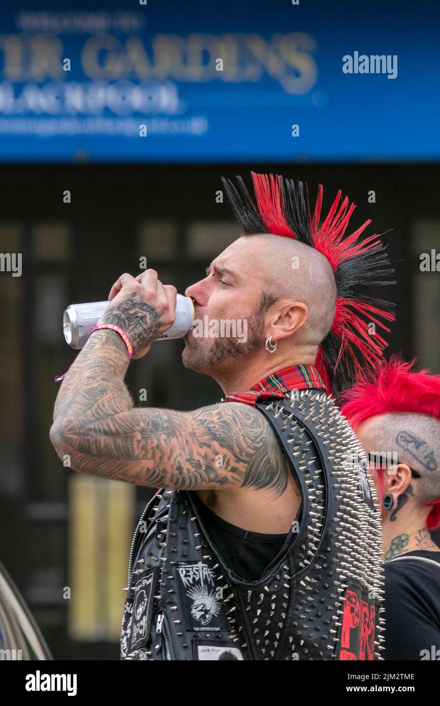 Blackpool, Lancashire, Regno Unito. 4th ago 2022. La sottocultura punk, le ideologie, la moda, con acconciature mohican tinted e la colorazione al festival punk Rebellion presso i Giardini d'Inverno. Una protesta contro atteggiamenti e comportamenti convenzionali, uno scontro di culture anti-establishment, mohawks, spille di sicurezza e un carico di atteggiamento alla città di mare come pugni che partecipano al festival annuale di musica rock Rebellion presso i Giardini invernali vengono a fianco a fianco con i tradizionali turisti. Credit: Cernan Elias/Alamy Live News Foto Stock