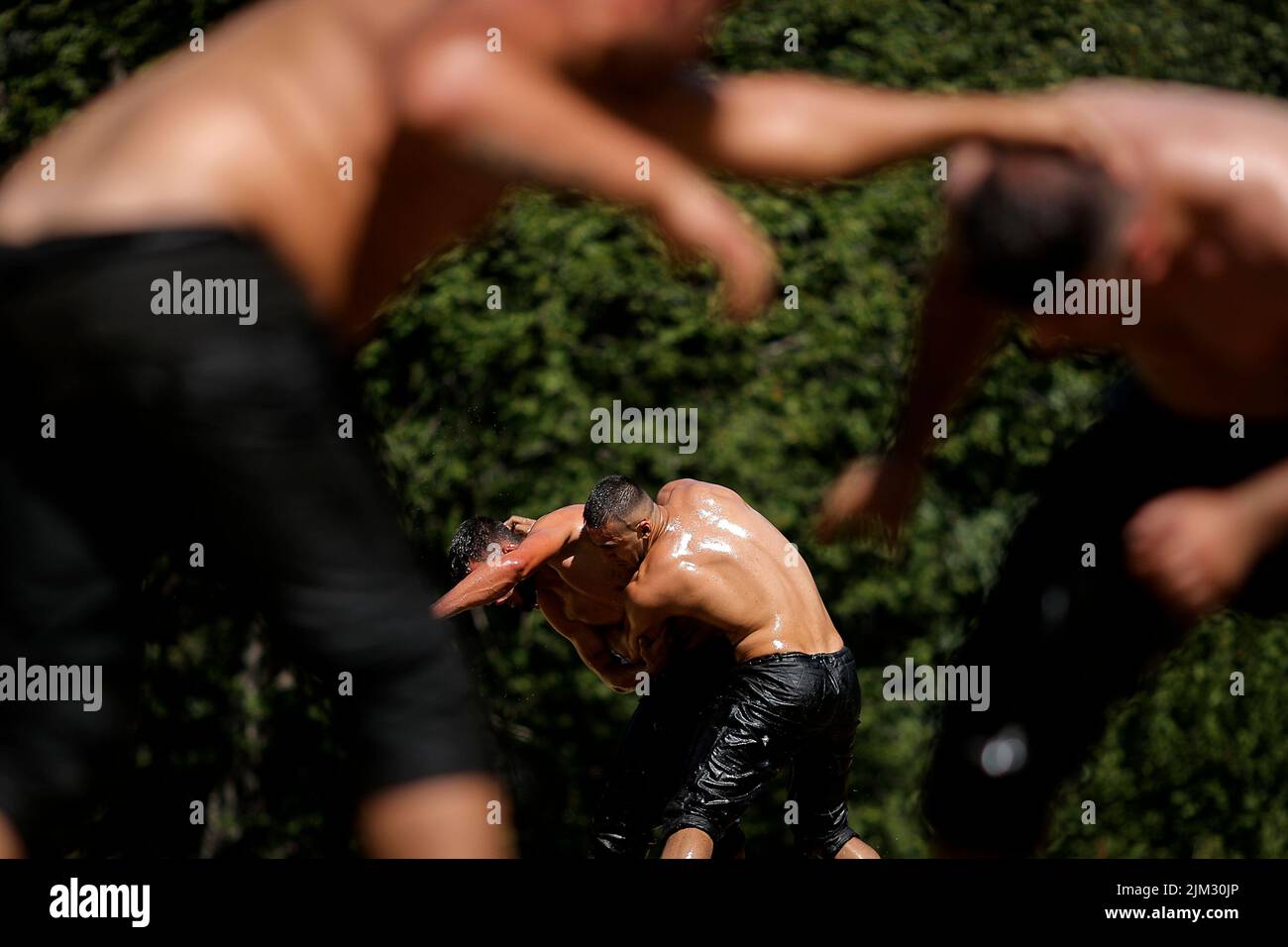 Gli acrobati si aggrappano in una tradizionale partita di lotta al petrolio chiamata 'Pelivani' durante il festival circoncisione nel villaggio di Donje Ljubinje, Kosovo, 03 agosto 2022. Ogni cinque anni la gente del villaggio organizza un Festival di ÔSunetŐ (circoncisione), che quest'anno ha circonciso più di 70 bambini. Tutti i membri del villaggio si riuniscono tra cui molti che vivono all'estero da Svizzera, Stati Uniti, Svezia e Germania, per il festival di tre giorni. Torbes Bosniaks sono abitanti che popolano il villaggio di Donje Ljubinje che si trova nelle montagne dello Shar che formano il borde Foto Stock