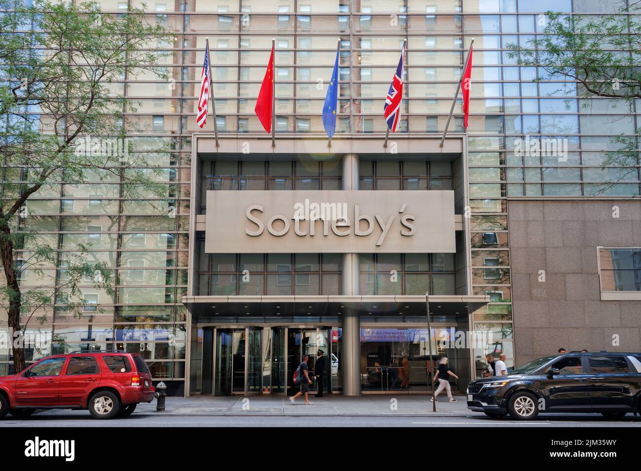 Sotheby's Auction House su York Avenue, nell'Upper East Side di Manhattan, New York City, ingresso principale con bandiere internazionali che volano sopra Foto Stock