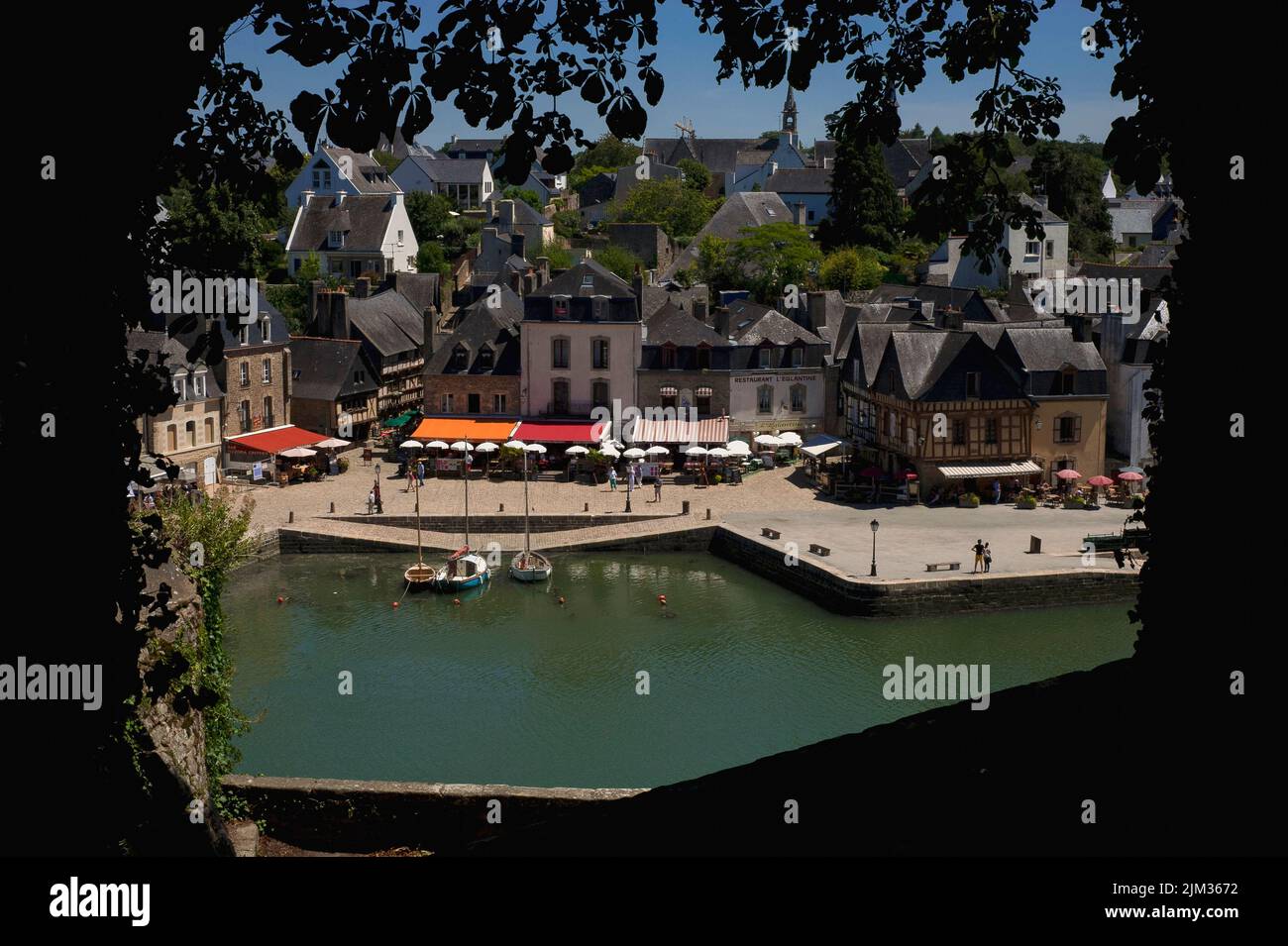 Ristoranti e caffè marciapiede con tende colorate e ombrelloni ora linea la Place Saint-Sauveur nel quartiere Saint-Goustan di Auray, Morbihan, Bretagna meridionale, Francia. Saint-Goustan, un tempo un porto di pesca e commerciale, è ora una popolare destinazione turistica che onora una visita del 1776 da parte del padre fondatore degli Stati Uniti, Benjamin Franklin. Foto Stock