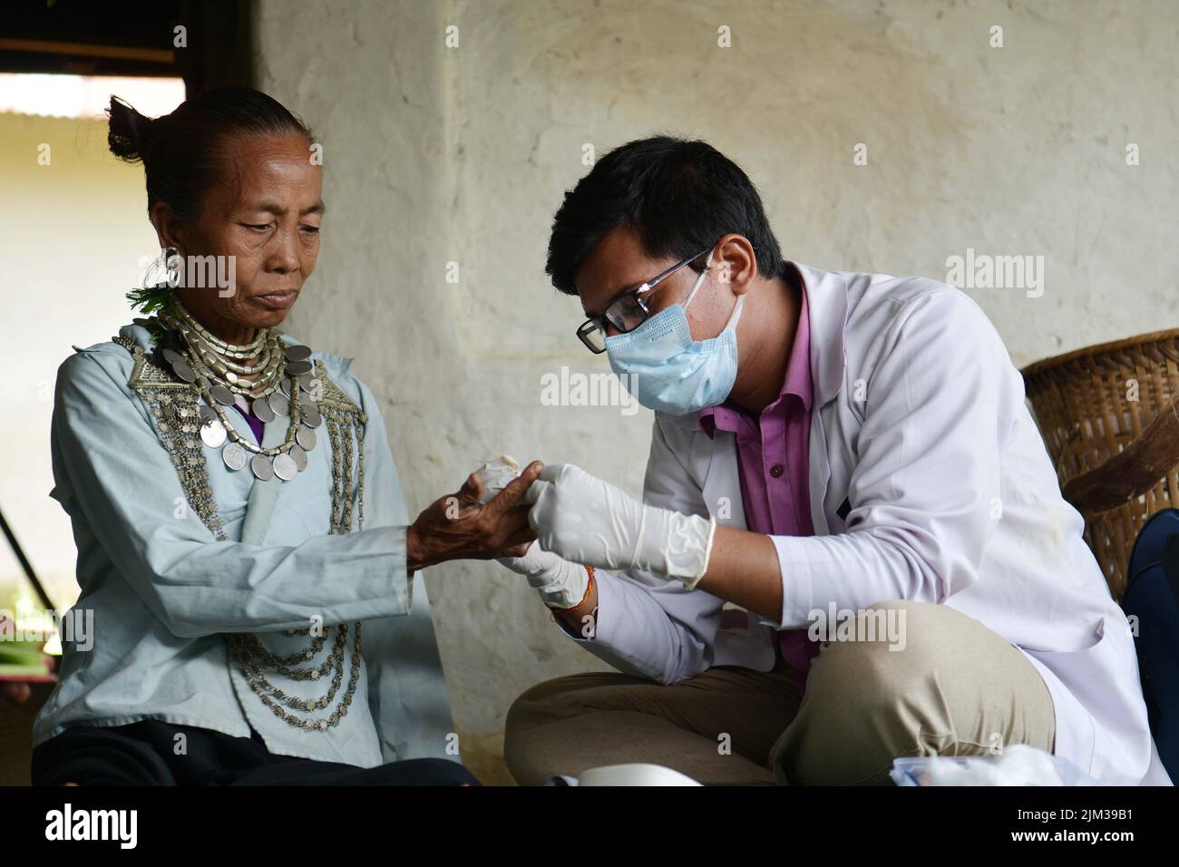 Soumit Kuri, un ufficiale di salute della Comunità che controlla la salute e che fornisce la medicina alla comunità tribale di Reang ad una capanna di bambù nel villaggio di Birendranagar, Jolaibari, Agartala, India. Foto Stock