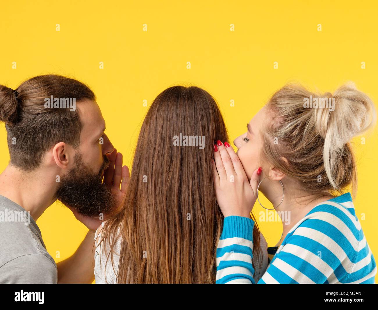 l'uomo di persuasione donna sussurra l'orecchio delle ragazze Foto Stock