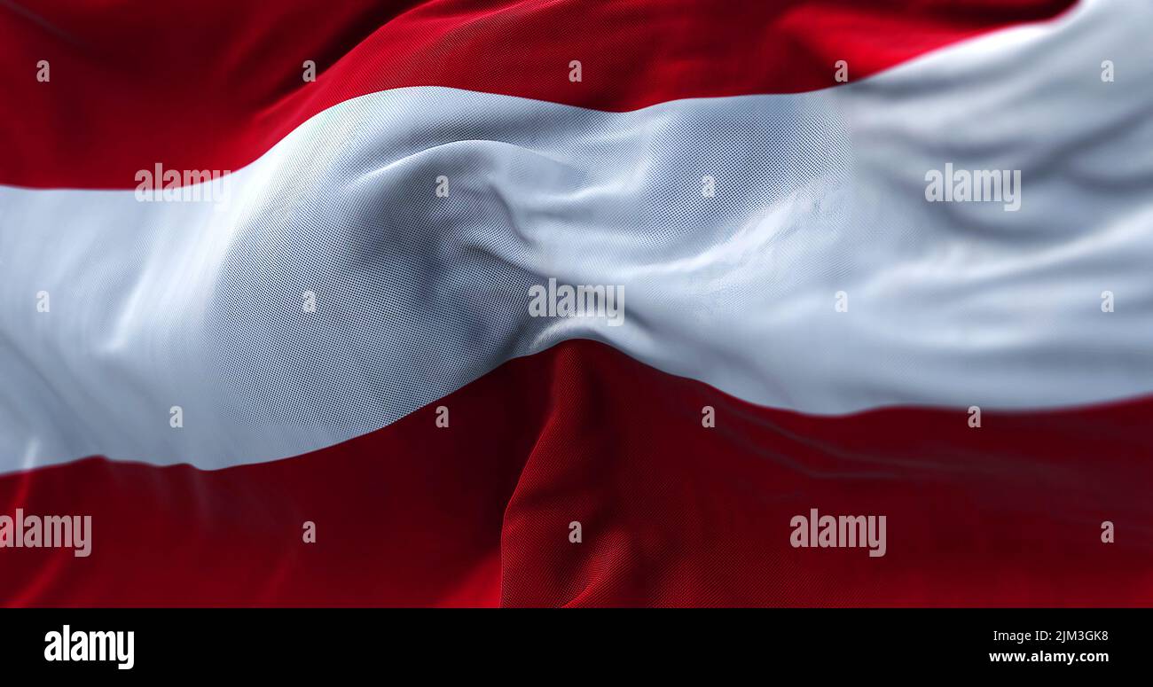 Vista ravvicinata della bandiera nazionale austriaca che sventola nel vento. L'Austria è un paese senza sbocco sul mare nella parte meridionale dell'Europa centrale. Tessitura del tessuto Foto Stock