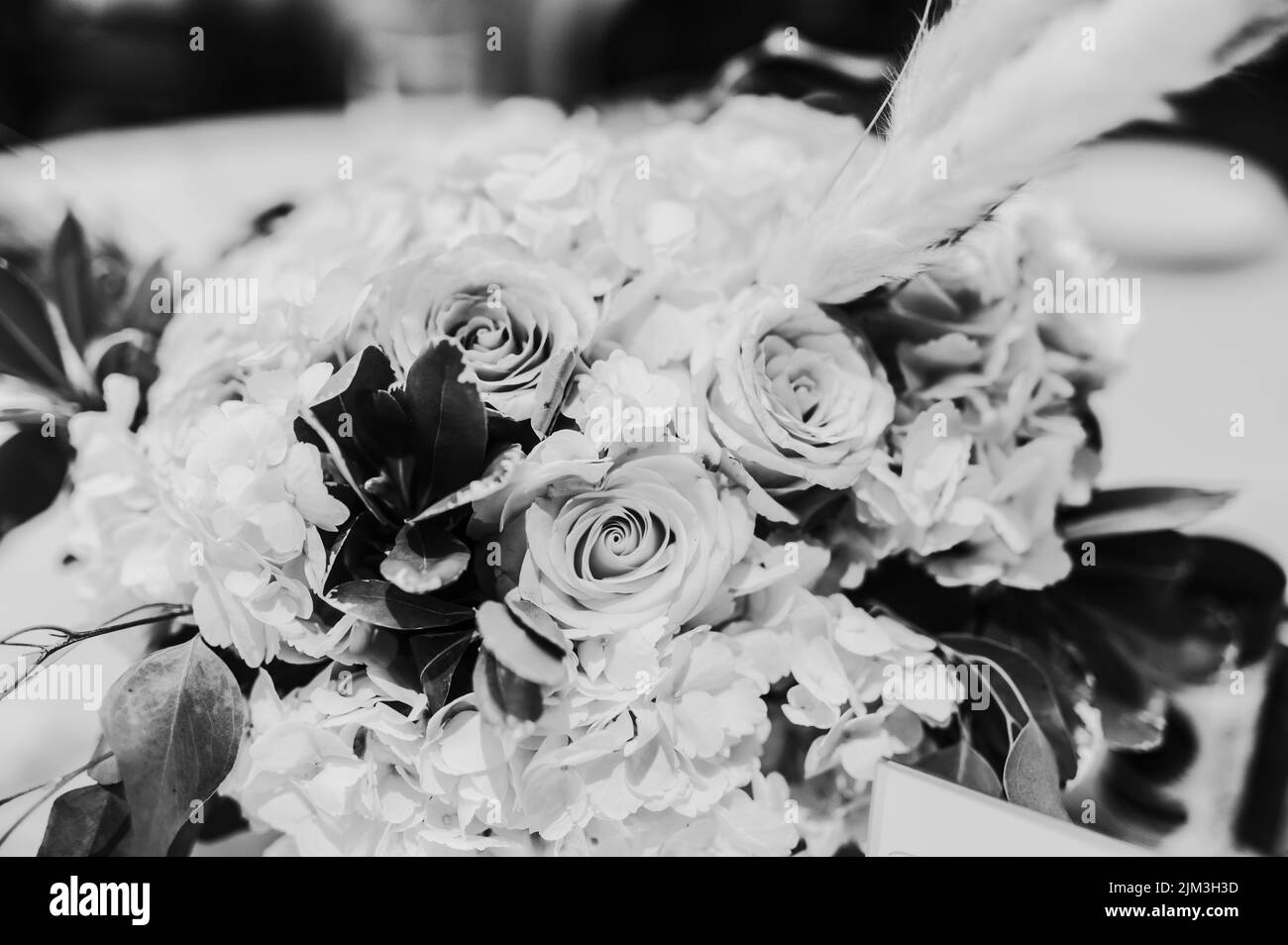 Un primo piano in scala di grigi di un bouquet con rose e altri fiori per un regalo Foto Stock