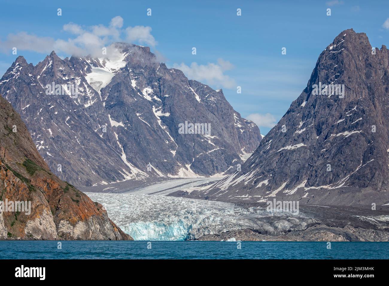 Grande ghiacciaio che scorre lungo la montagna verso il mare a Evighedsfjord, Groenlandia Foto Stock