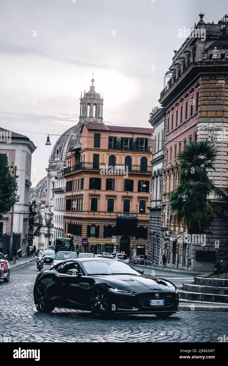 Una foto verticale di una lussuosa supercar jaguar nera che guida nel centro di Roma, Italia Foto Stock