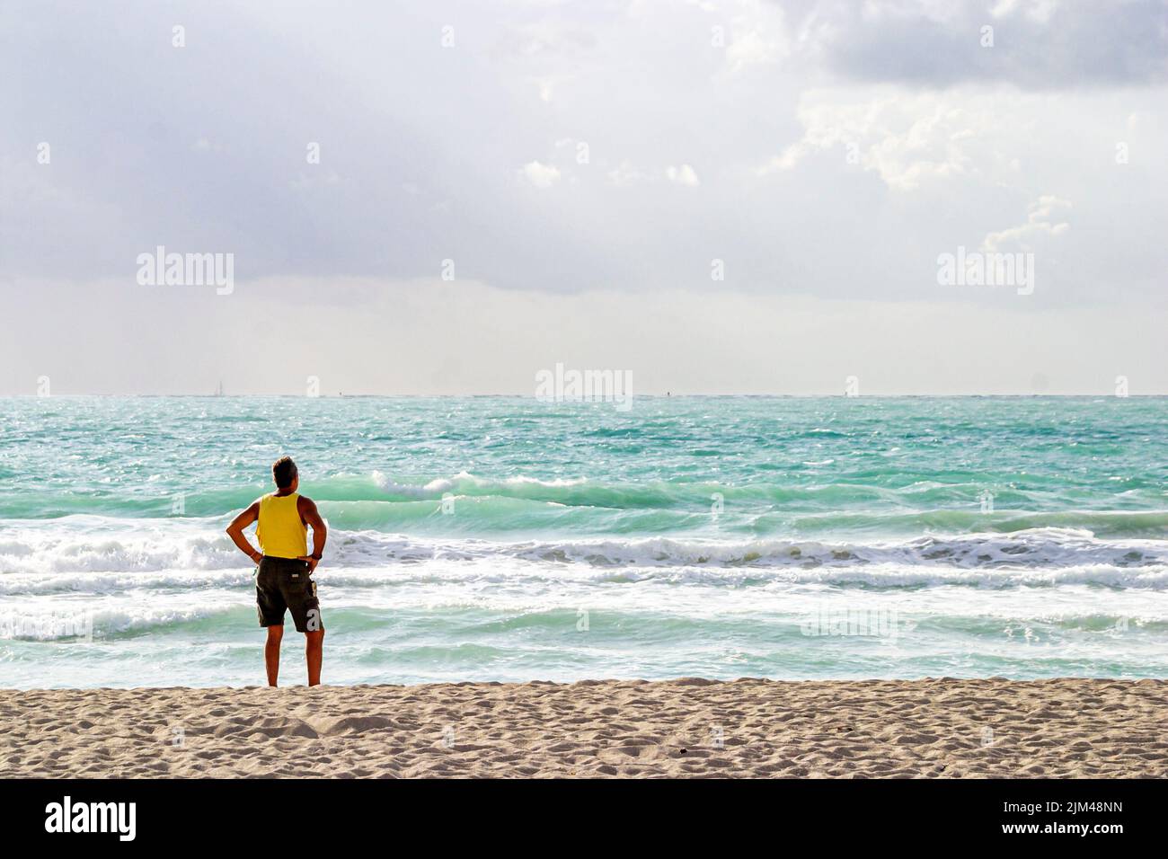 Miami Beach Florida, Oceano Atlantico costa costa surf onde costa pubblico, adulti uomini uomo uomo maschio beachcomber in piedi cercando Foto Stock