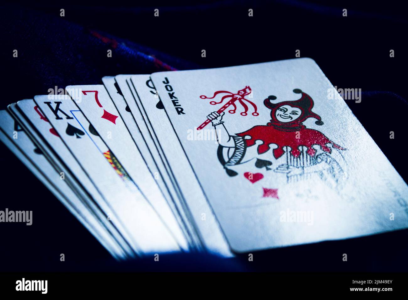 Un primo piano di un mazzo sparso di carte su una superficie scura Foto Stock