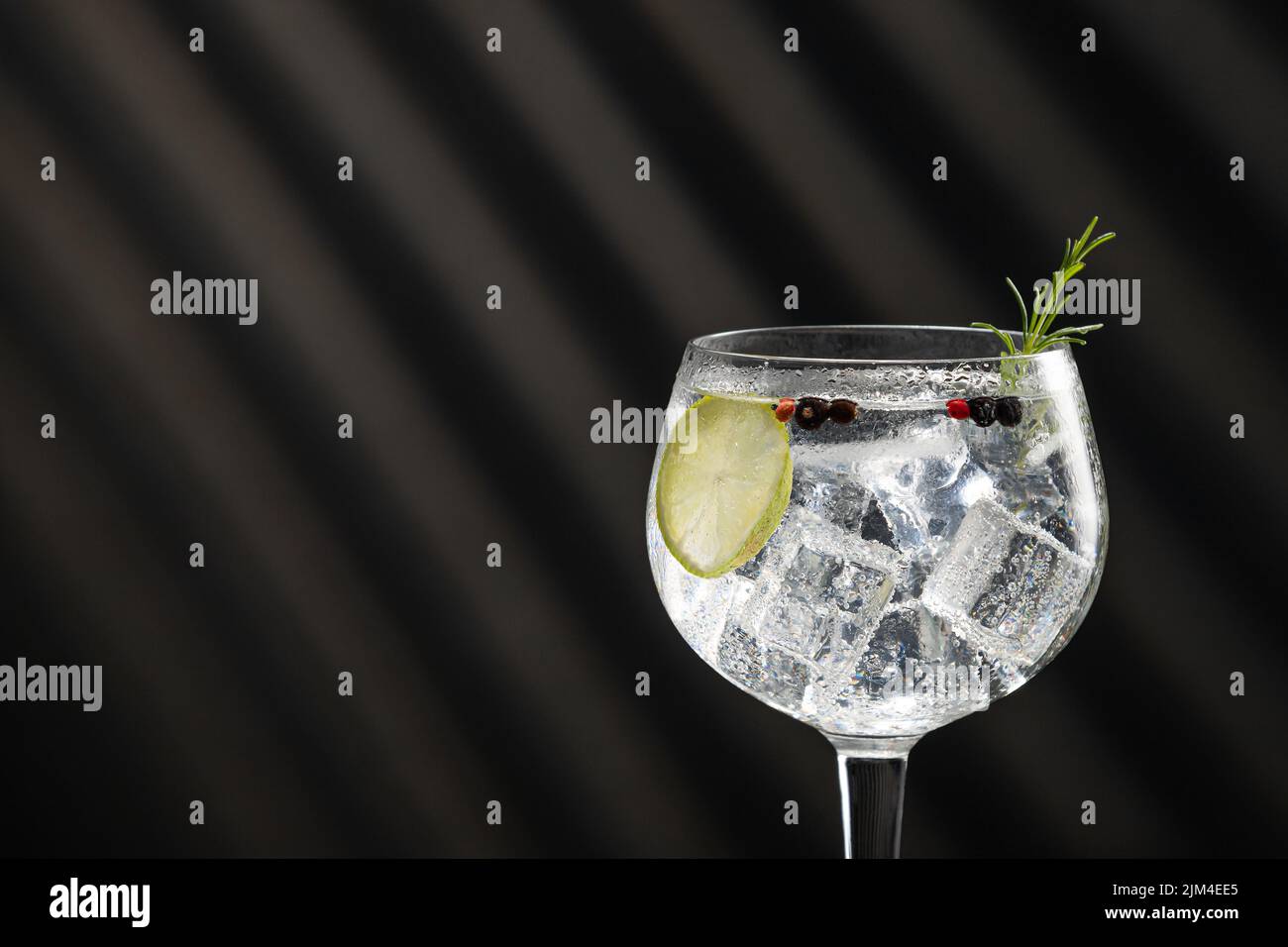 Primo piano di cocktail gin tonic con ombre e spazio per le copie. Foto Stock