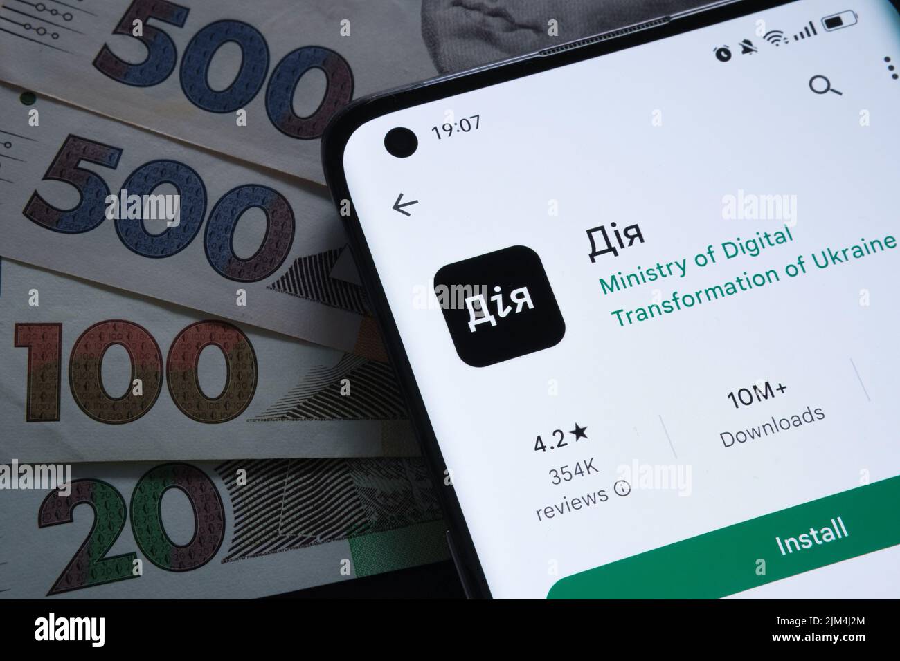 L'app Diia sullo schermo dello smartphone è posizionata sulle banconote di hryvna. Le parole ucraine viste sulla foto traducono come 'azione', 'azione app'. L'app 'iia' è lo stato i. Foto Stock