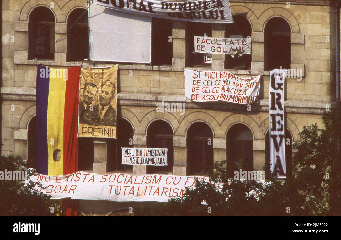 Bucarest, Romania, aprile 1990. 'Golaniada', una grande protesta anti-comunismo in Piazza dell'Università dopo la Rivoluzione rumena del 1989. La gente si riunì ogni giorno per protestare contro gli ex comunisti che presero il potere dopo la Rivoluzione. Vari striscioni sono appesi alle pareti dell'edificio universitario. Foto Stock